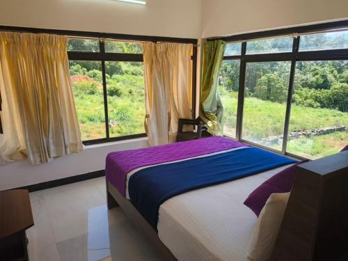a bedroom with a bed and a large window at SD Residency - Yercaud in Yercaud