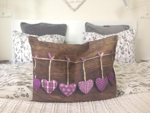 a pillow with four hearts hanging on a bed at Traubengarten Winkler in Niederhollabrunn