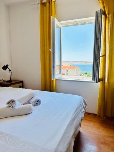 a bedroom with a bed and a large window at PHOS - Pag Residences in Kustići