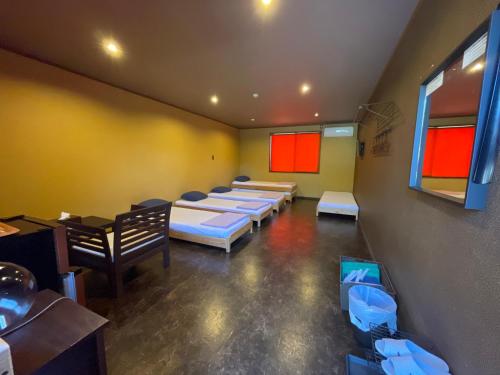 a room with rows of beds and tables and chairs at スパイス平戸 in Hirado