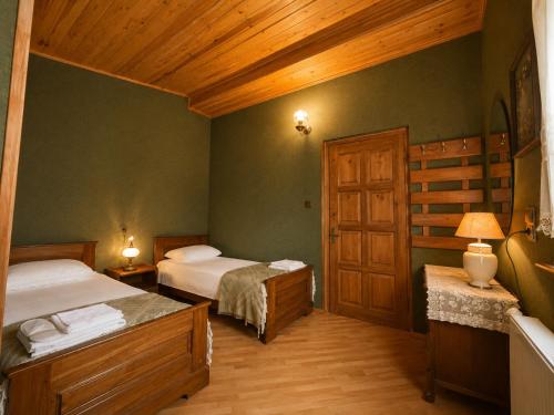 a bedroom with two beds and a wooden ceiling at Milorava's Guest House & Wine Cellar in Telavi