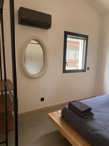 a bedroom with a bed and a round mirror at La Villa Véga 8 pers in Martillac