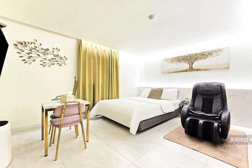 a bedroom with a bed and a desk and a chair at 호텔벨르 in Pyeongtaek