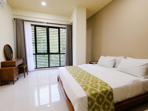 a bedroom with a large bed and a large window at Apatto Bajo in Labuan Bajo
