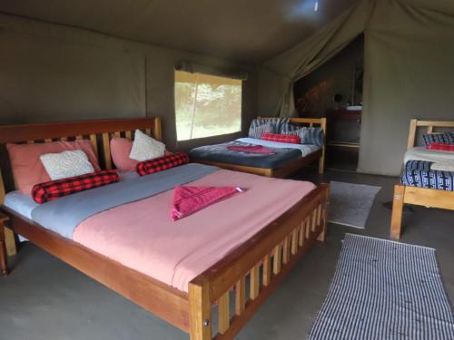 a bedroom with two beds in a tent at Sunshine maasai mara safari camp in Sekenani