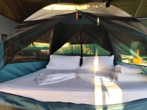 a bed in a tent with towels on it at Relax Camping in Gjirokastër