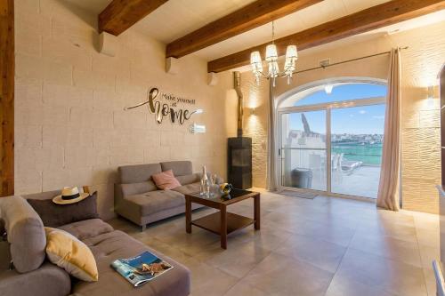 a living room with a couch and a table at Inni Gozitan Farmhouse Private Pool- Happy Rentals in Santu Pietru