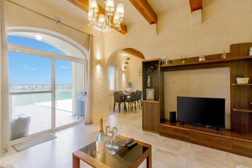 a living room with a tv and a large window at Inni Gozitan Farmhouse Private Pool- Happy Rentals in Santu Pietru