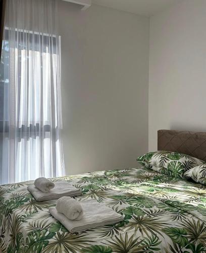 a bed with towels on it with a window at Miris Mora in Rafailovici