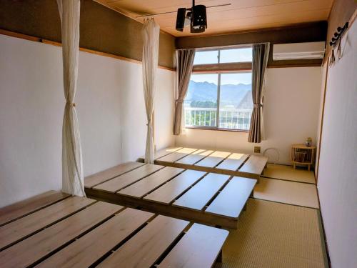 a room with two beds and a window at ゲストハウス凪季のやど in Nachikatsuura