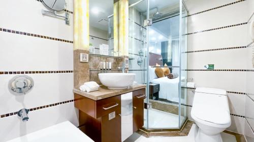 a bathroom with a toilet and a glass shower at Merry Hotel Shanghai in Shanghai