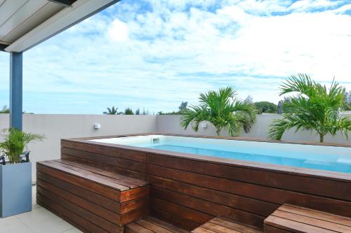 a swimming pool on a balcony with a wooden fence at Villa Eden - 2 bedrooms with Private Rooftop Terrace & Pool, Ki Residences, Pereybère - KSN Collection Privée in Grand-Baie