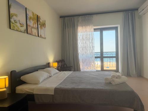 a bedroom with a bed with two towels on it at Hotel Olimp in Zatoka