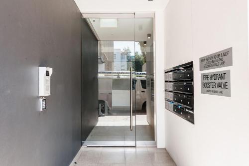 a glass door leading into a room with a van at Cozy Bondi Apartment Heated Winter Stay in Sydney