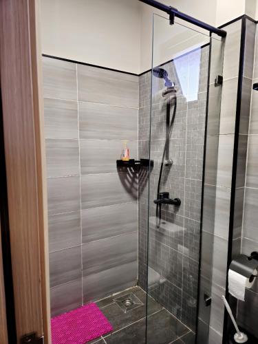 a shower with a glass door in a bathroom at JKIA Transit Hub in Syokimau