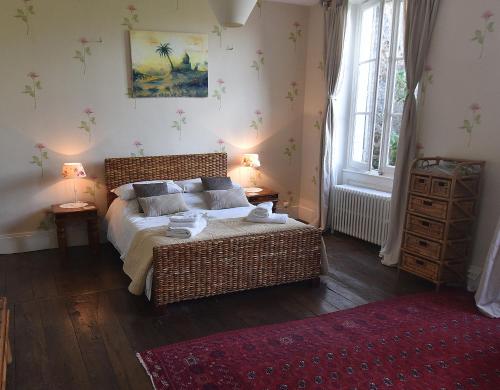 a bedroom with a wicker bed and a window at Maison du Magnolia in Confolens