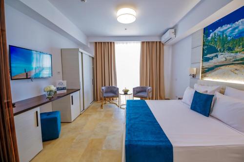 a hotel room with a bed and a tv at Mera Maris in Cap Aurora