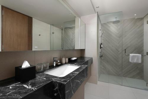 a bathroom with a sink and a mirror at Somerset Central Salcedo Makati in Manila