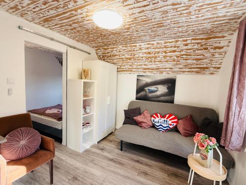 a living room with a couch and a bed at Balcsitthon Apartmanok in Siófok