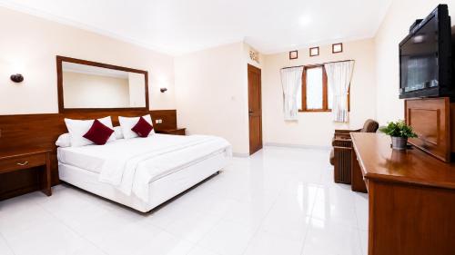 a bedroom with a bed and a flat screen tv at Cemara Asri Guesthouse in Lembang