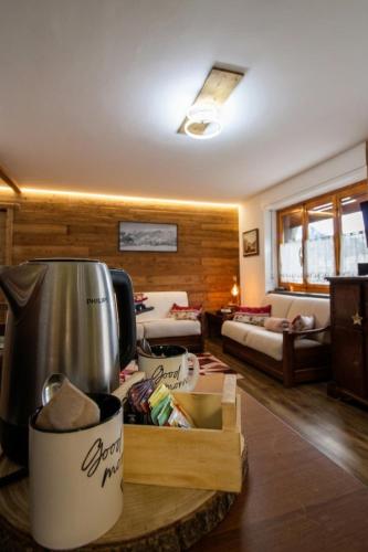 a living room with a table with a pot on it at Chalet La Cometa in Sauze dʼOulx