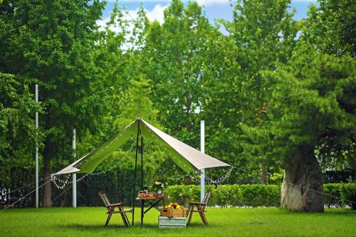 a tent in the grass with a table and chairs at JW Marriott Hotel Beijing in Beijing