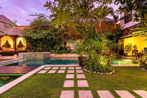 a garden with a swimming pool in a house at Villa Yasmin in Seminyak