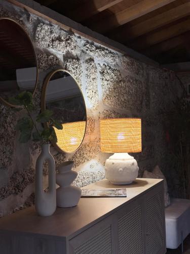 a table with a mirror and a vase and a lamp at Pedacinho do Céu in Vieira do Minho
