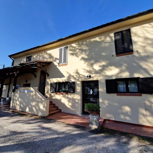 a white house with a porch and a door at Hotel Collina di San Sisto in San Sisto