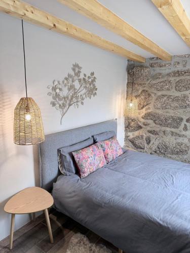 a bedroom with a gray bed and a table at Pedacinho do Céu in Vieira do Minho