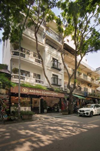 a white car parked in front of a building at Bastra Classy Hotel in Hanoi