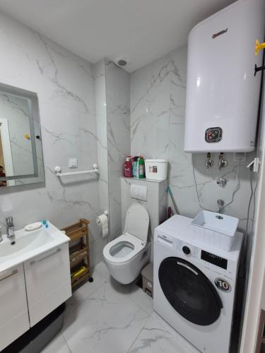 a white bathroom with a toilet and a sink at Family Home Apartment in Bar