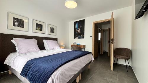 a bedroom with a large bed and a chair at Villa Lagune in Les Sables-d'Olonne