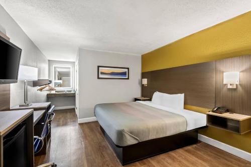 a hotel room with a bed and a desk at Quality Inn near Blue Spring in Orange City