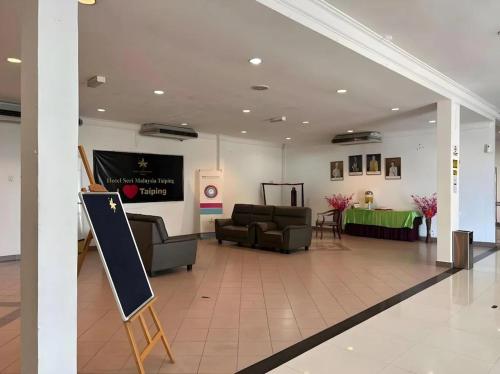 a lobby with couches and a chalkboard in a building at Hotel Seri Malaysia Taiping in Taiping
