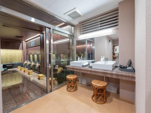 a bathroom with two sinks and two mirrors at Subaruyado Yoshino in Tokushima