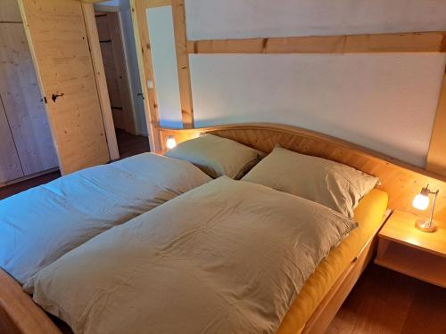 a bed with two pillows on it in a room at Hüthis Waldidylle in Dambach