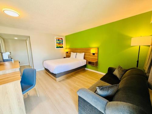 a hotel room with a bed and a couch at Park Inn by Radisson, Quesnel in Quesnel