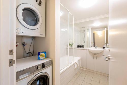 a bathroom with a washing machine and a sink at MainStay Suites Williamstown in Williamstown
