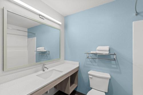 a bathroom with a white toilet and a mirror at WoodSpring Suites Atlanta Canton in Canton