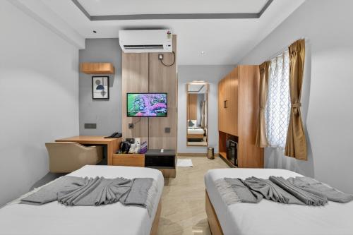 a hotel room with two beds and a television at 23 Urban Square in Hyderabad