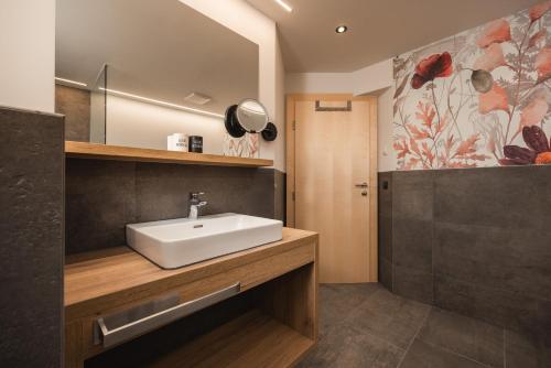 a bathroom with a sink and a mirror at Apart Hotel Garni Kofler in Fiss