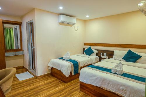 a hotel room with two beds and a window at Bardibas Resort in Tulsi