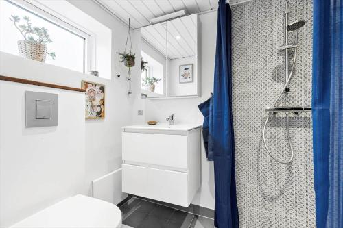 a white bathroom with a shower and a sink at 8528-Grenaa-Klitten-28 in Grenå