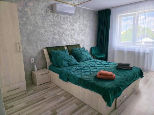 a bedroom with a bed with green sheets and a window at Ram house1 in Piteşti