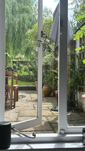 an open door to a garden with a patio at Garden View Homestay in Historic Patcham, Brighton in Brighton & Hove