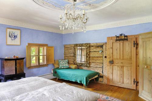 a bedroom with blue walls and a bed and a chandelier at Ferienhaus Stadlerhof in Rettenschöss