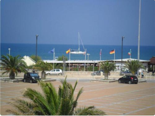 a parking lot with flags in front of the ocean at Appartamenti Bramante in Vieste