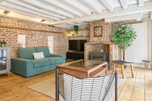 a living room with a couch and a brick fireplace at Old Town - Lovely typical house in Lille