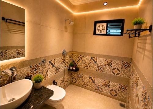 a bathroom with a white toilet and a sink at The Boho Peach Villa in Mount Ābu